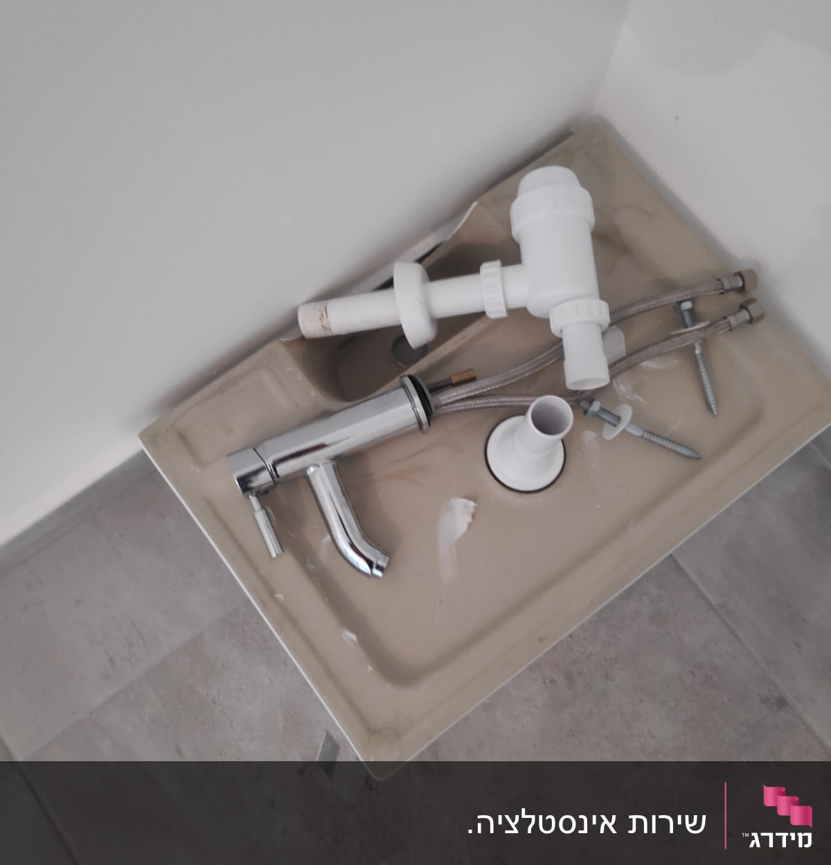 כיור עם ברז וכלי אינסטלציה מונחים עליו